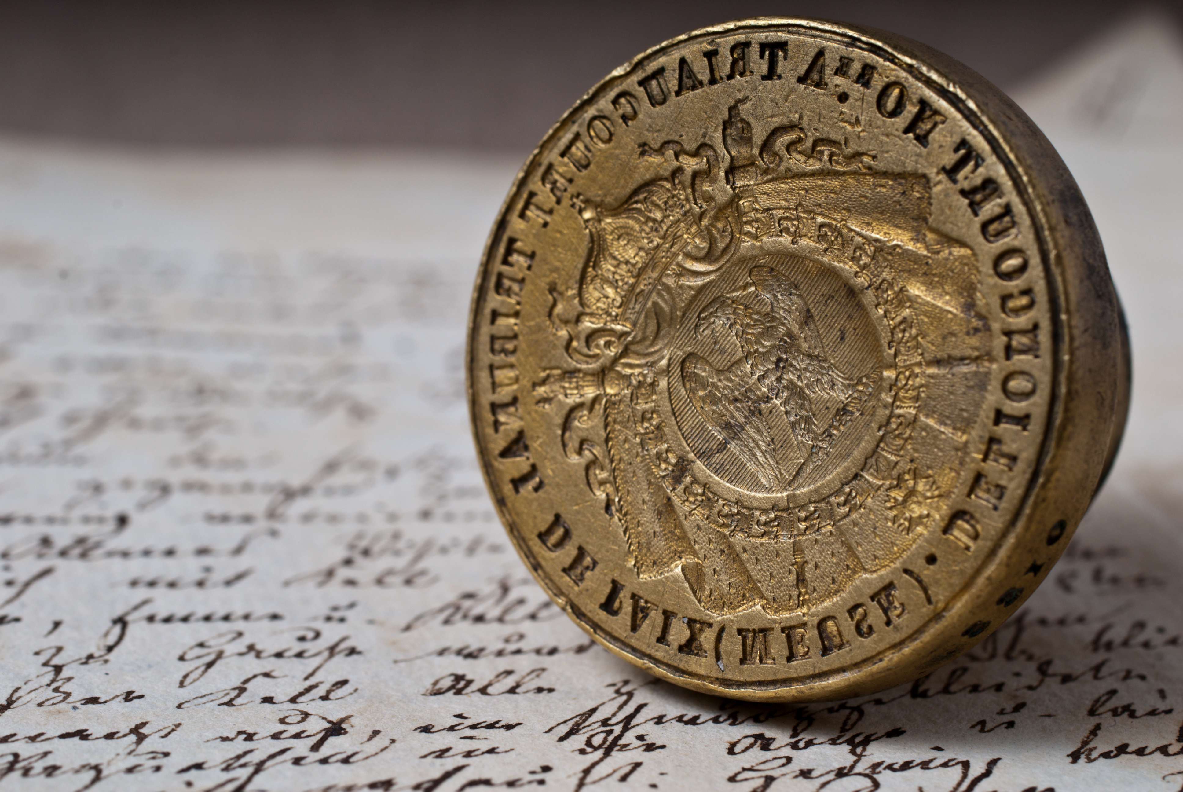 Altes handschriftliches Dokument mit einem Metallsiegel daraufliegend