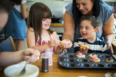 Kinder mit Trisomie 21 backen Cupcakes Familie beim Cupcake backen