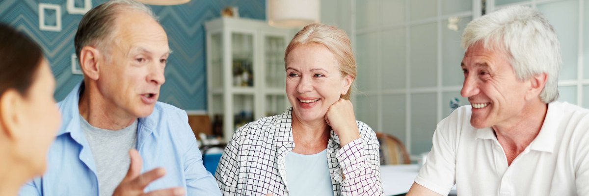 Seniorinnen und Senioren unterhalten sich bei einer Tasse Kaffee