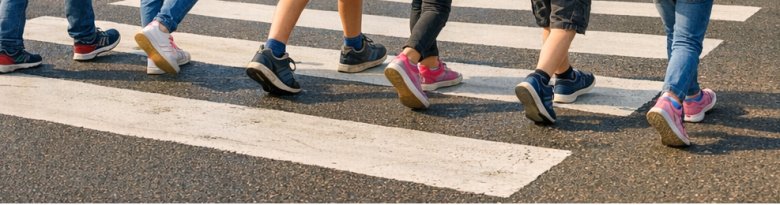 Schulkinder auf Fußgängerüberweg Schulkinder laufen über einen Fußgängerüberweg; zu sehen sind allerdings nur die Füße und die Beine